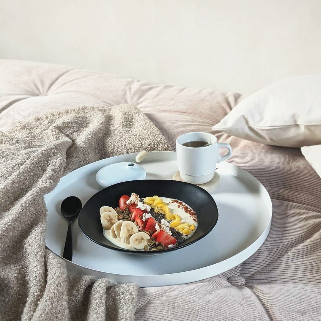 Charola con desayuno sobre el colchón capitoneado del futón